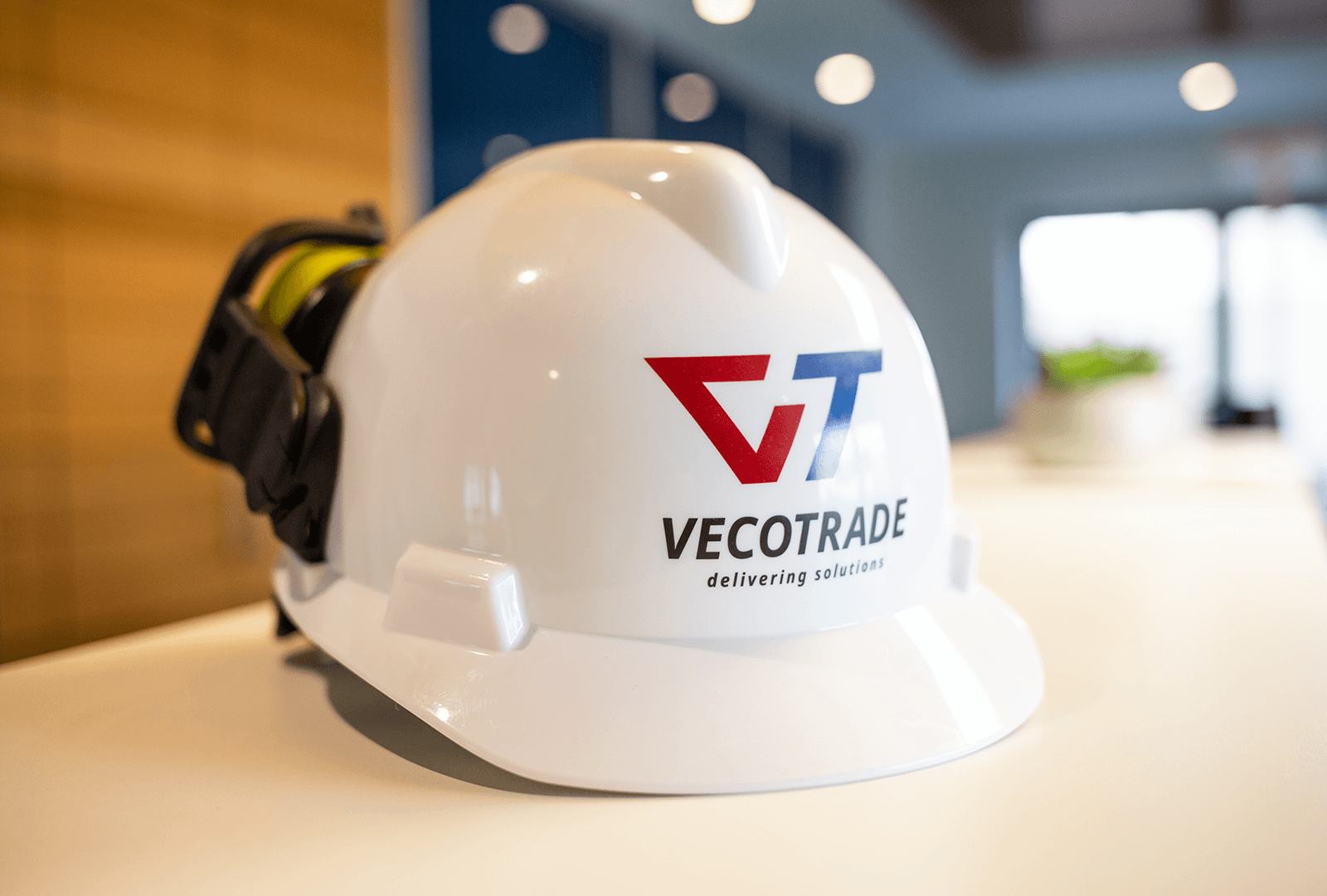 Casque de sécurité blanc avec le logo Vecotrade sur une table de réunion